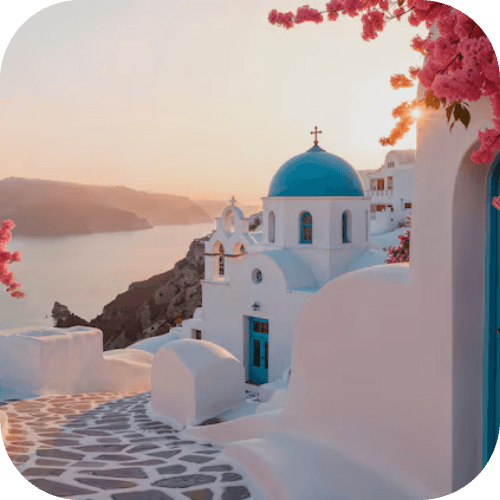 Tramonto su un villaggio greco imbiancato con chiesa dalla cupola blu