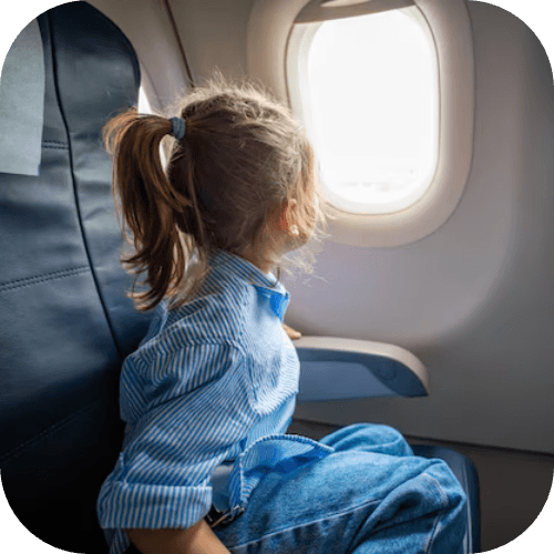 Bambina che guarda fuori dal finestrino di un aereo in volo
